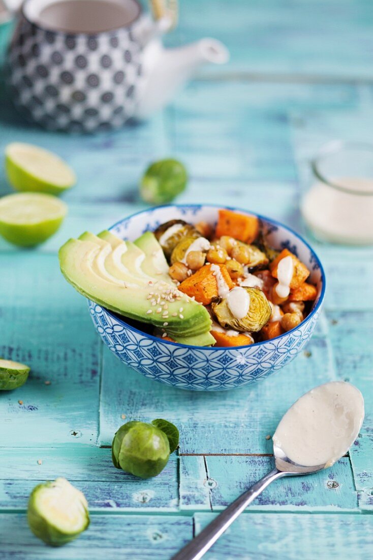 A Buddha bowl with sweet potatoes, brussels sprouts, and avocado