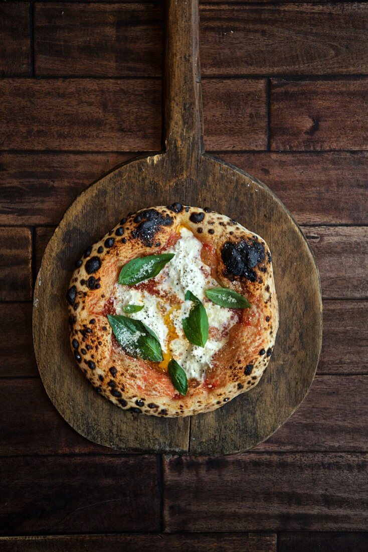 Pizza Neapolitana mit Burrata, Olivenöl und Basilikum (Aufsicht)