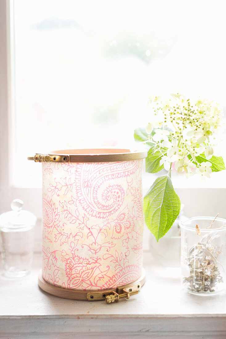 Lantern made from paper and embroidery frames on windowsill