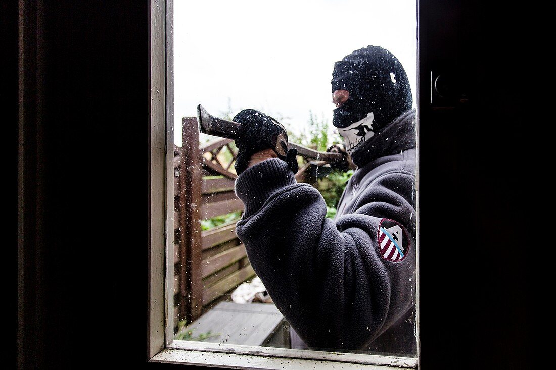 Burglar using a crowbar on a window