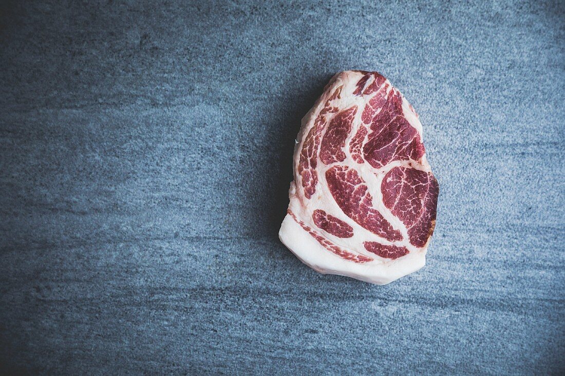 Raw free-range, organic pork steak (seen from above)