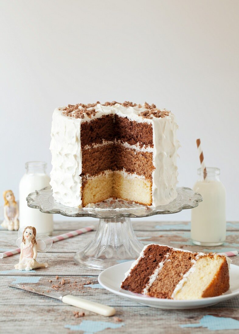 A triple-layered chocolate cake with a slice cut out