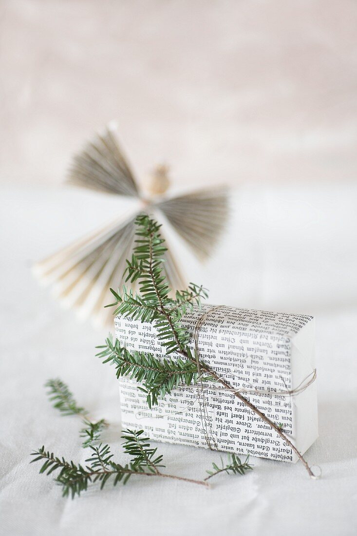 In Buchseiten eingepacktes Geschenk mit Tannenzweig