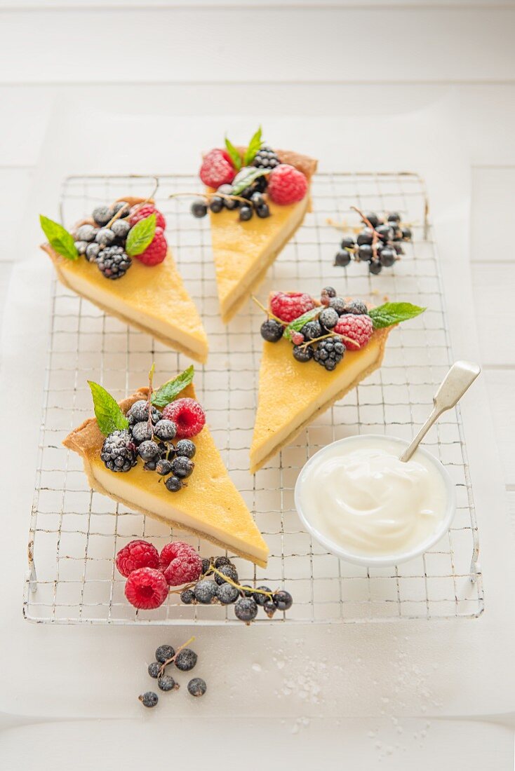 A vanilla tart decorated with fresh berries and cut into slices