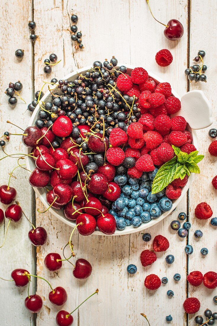 Kirschen, Heidelbeeren, schwarze Johannisbeeren und Himbeeren in einer Schüssel