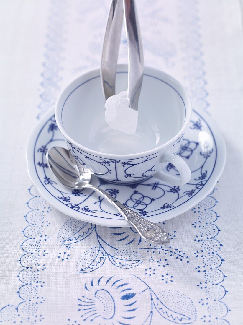 Ostfriesentee zubereiten: Kandiszucker in die Teetasse geben