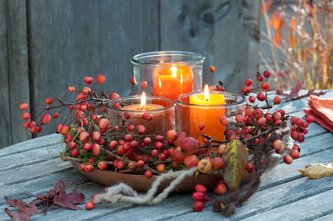 Wreath of malus branches with fruits and lanterns