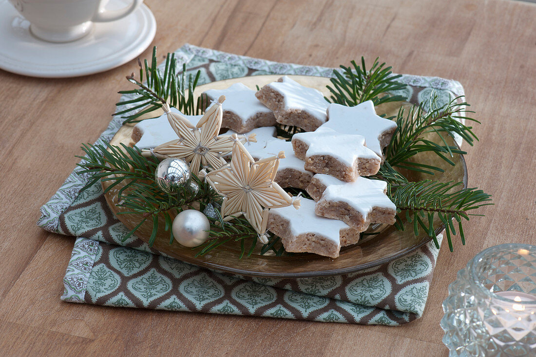 Weihnachtsteller mit Zimtsternen, Strohsternen, silbernen Kugeln