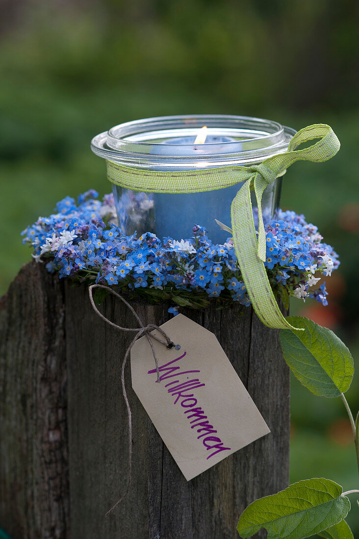 Small preserving jar as lantern in Myosotis wreath