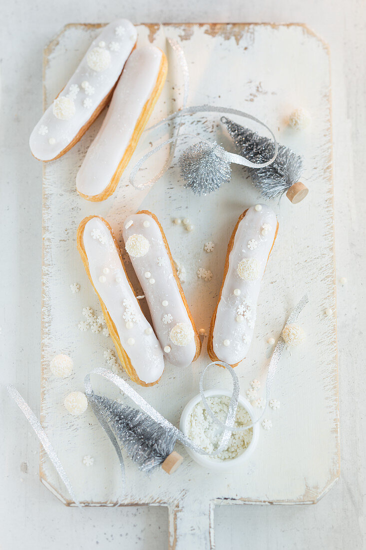 Eclairs decorated with white glaze and sugar stars for Christmas