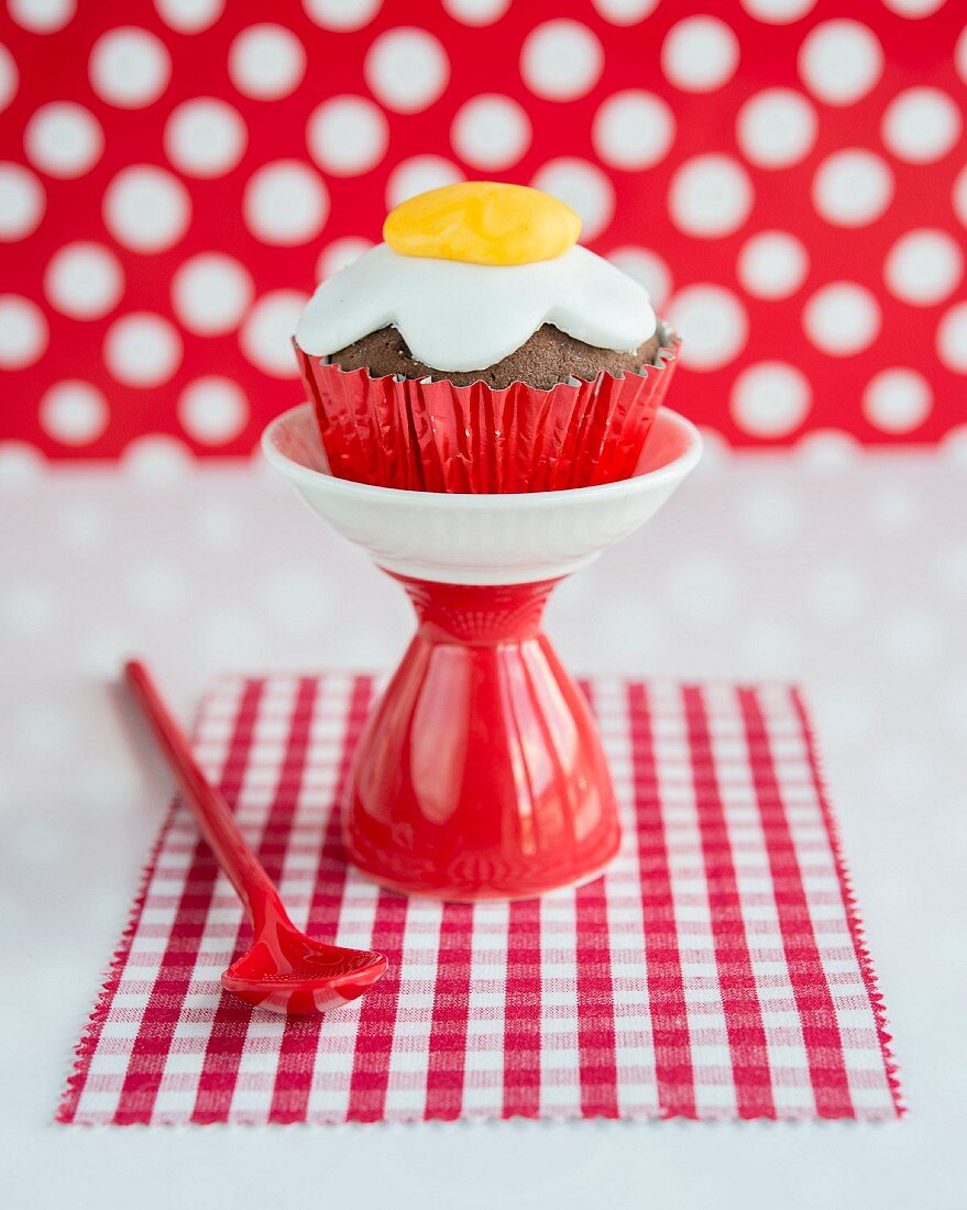 A cupcake decorated with a fondant fried egg