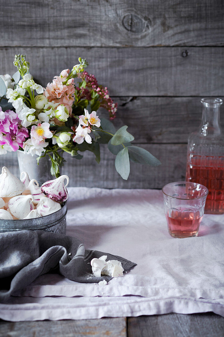 Baisergebäck und Blumen auf einem Tisch