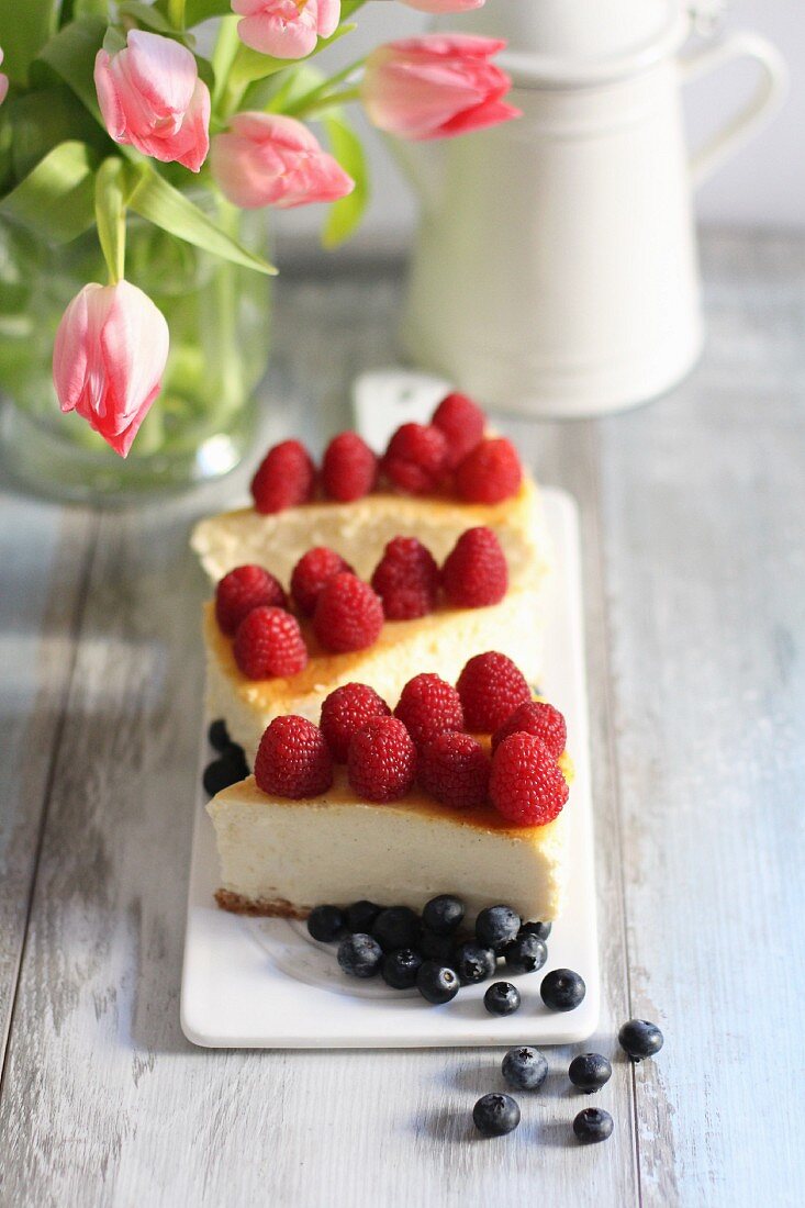 Slices of cheesecake with raspberries and blueberries