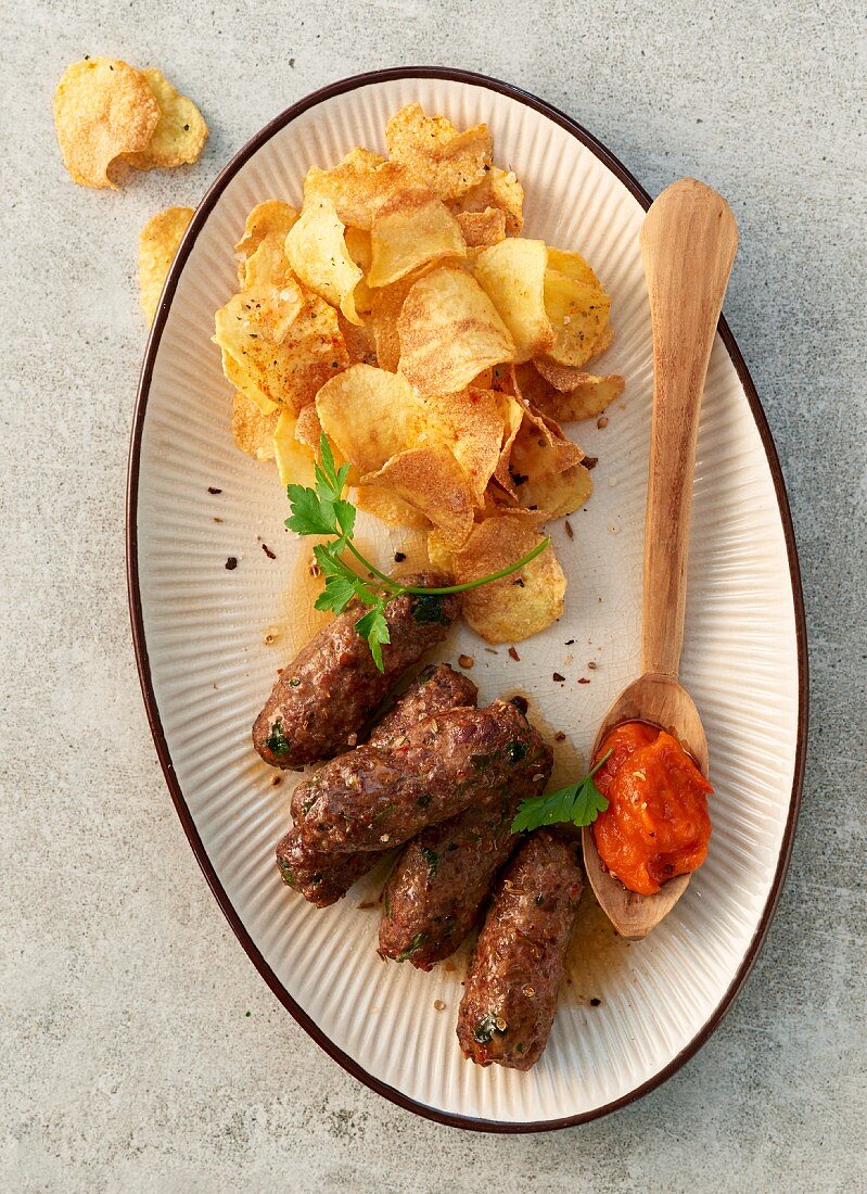 Cevapcici with potato chips and Ajvar (top view)