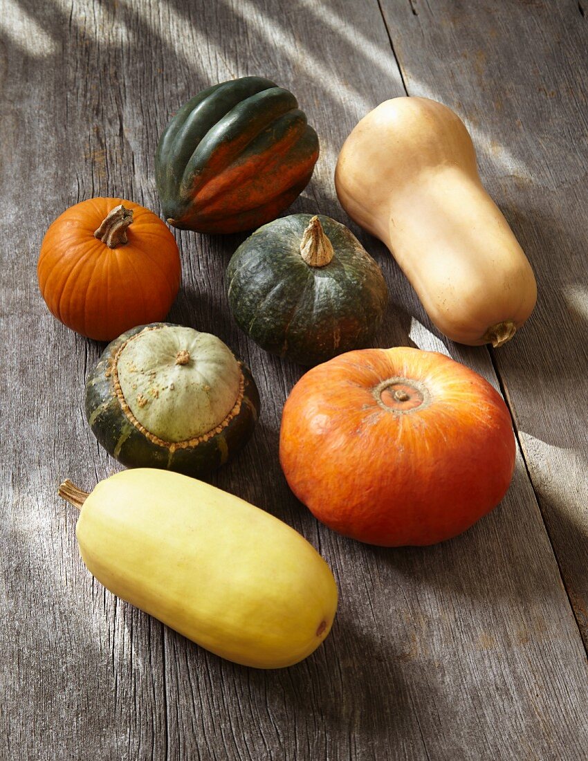 Various pumpkins on a wooden surface