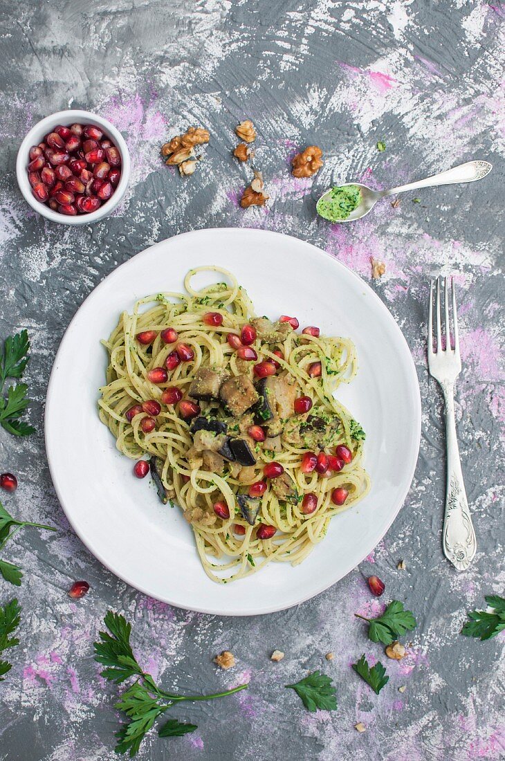 Spaghetti with parsley and walnut pesto, eggplant, and pomegranate