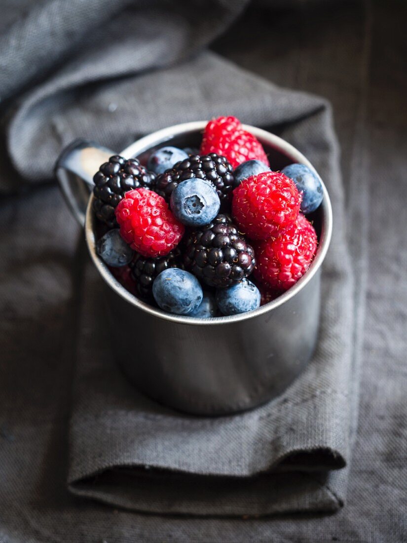 Mix of summer berries in a metal cup
