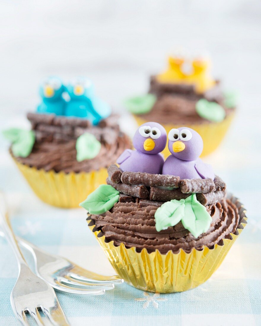 Frühlingshafte Schokoladencupcakes verziert mit Fondant-Vögeln