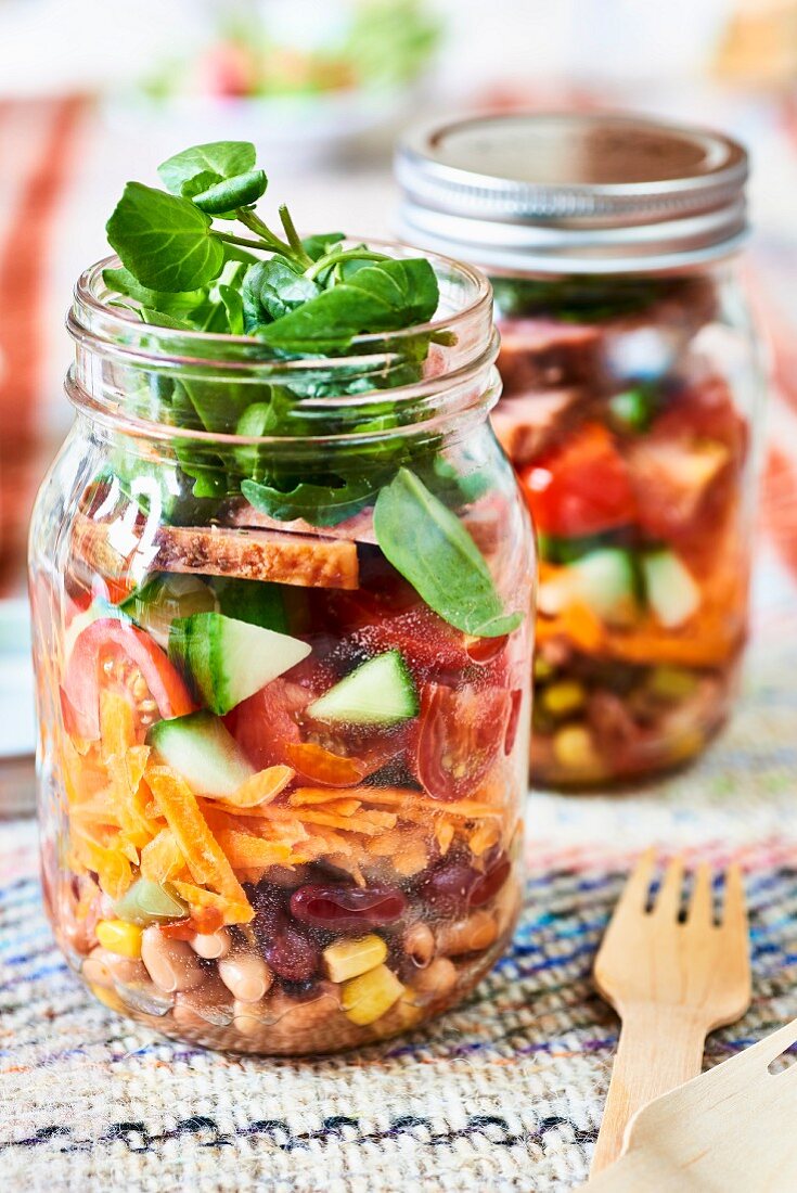 Vegetable salads in glass jars (picnic food)
