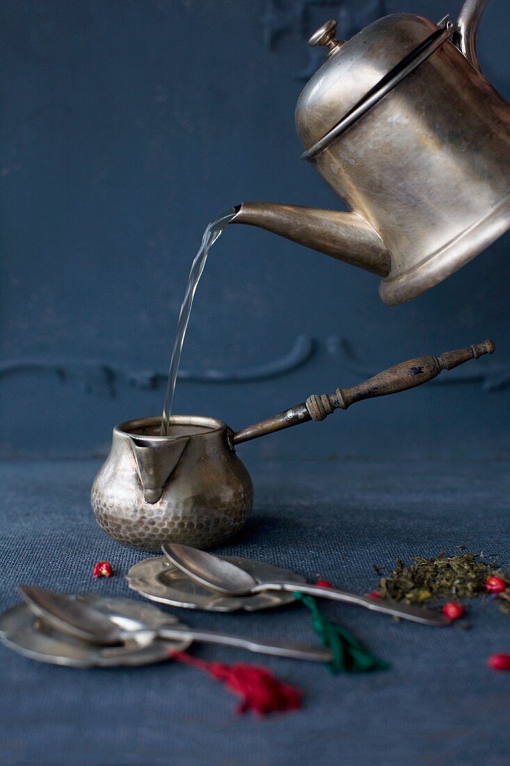 Making tea with a silver teapot