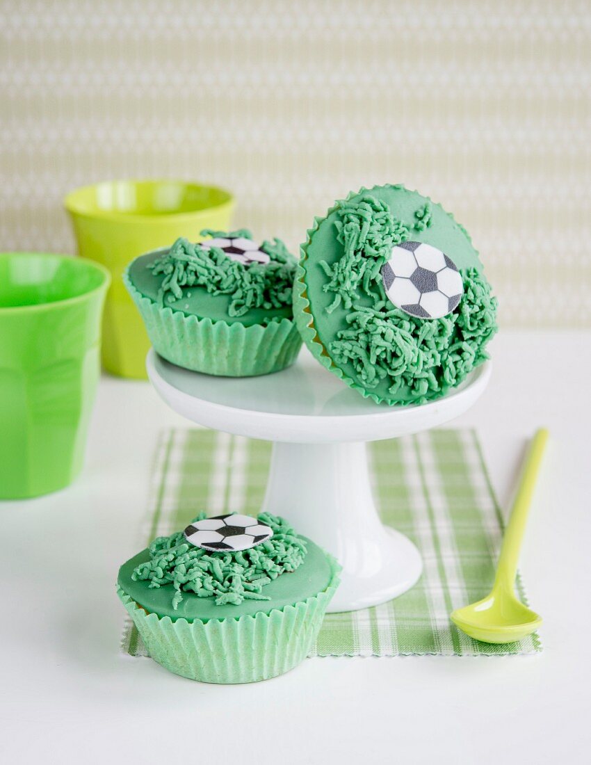 Green cupcakes decorated with footballs and grass