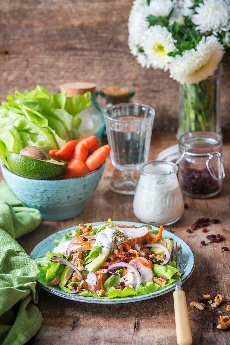Salad with carrots, walnuts, avocado, onions and roast chicken