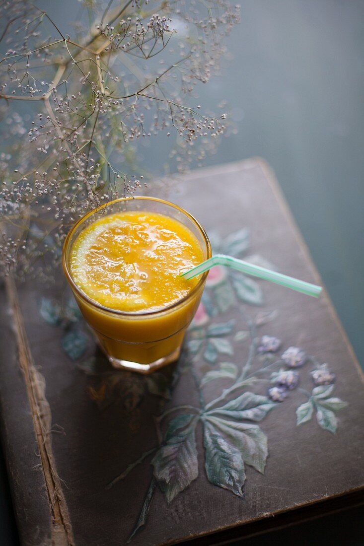 Orangensaft im Glas mit Strohhalm