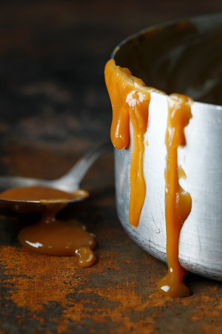 Caramel sauce dripping from a saucepan