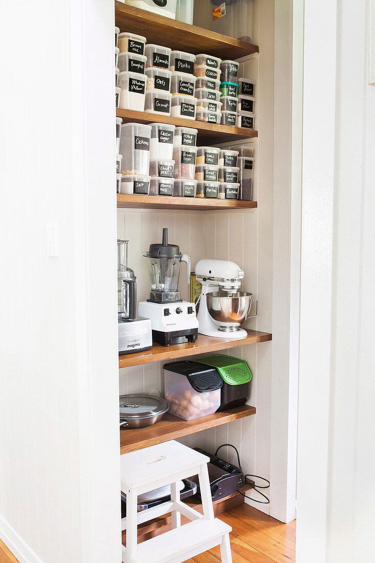 Shelves with storage jars and kitchen appliances in the pantry