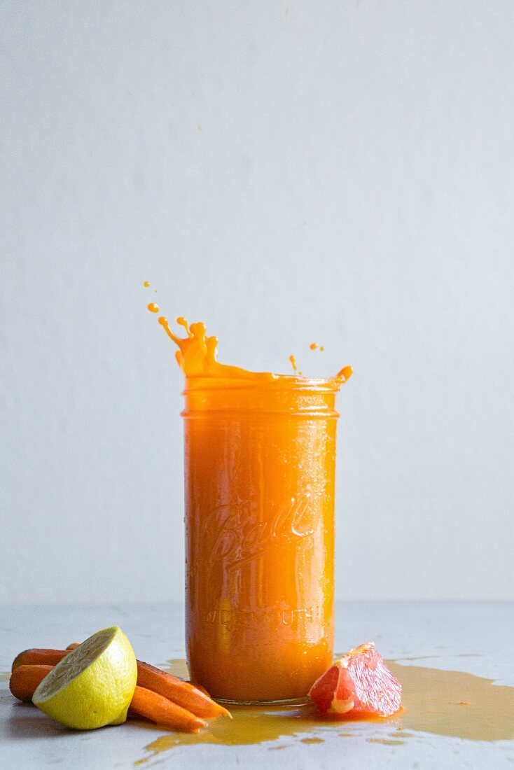 Carrot, grapefruit, and lemon juice in a screw top glass
