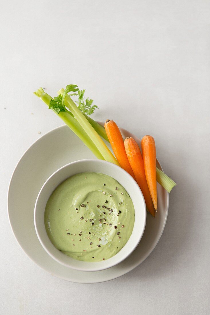 A tahini and coriander dip with pepper, sea salt flakes and carrot and celery sticks