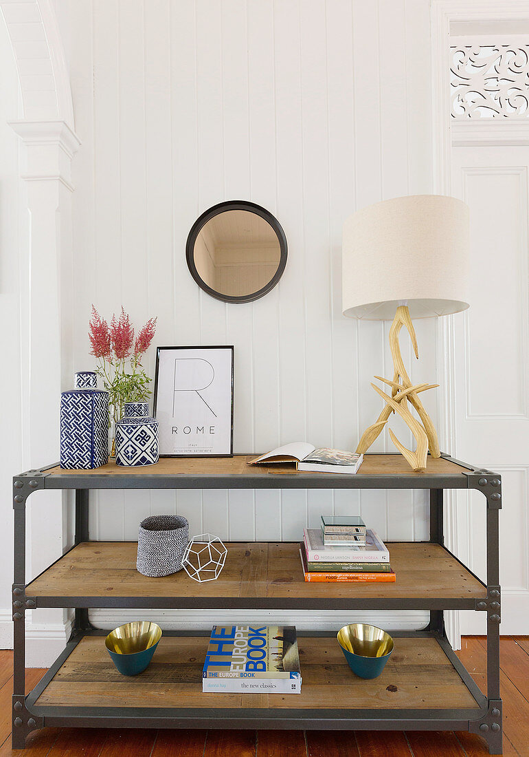 Industrial style shelf with decorative accessories and a table lamp