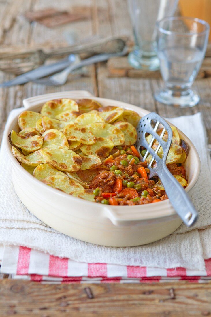 Potato bake with mince, carrots and peas