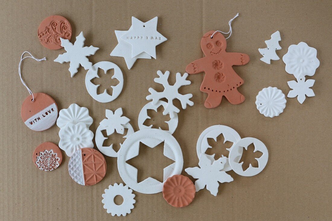 Clay Christmas decorations in white and terracotta on cardboard