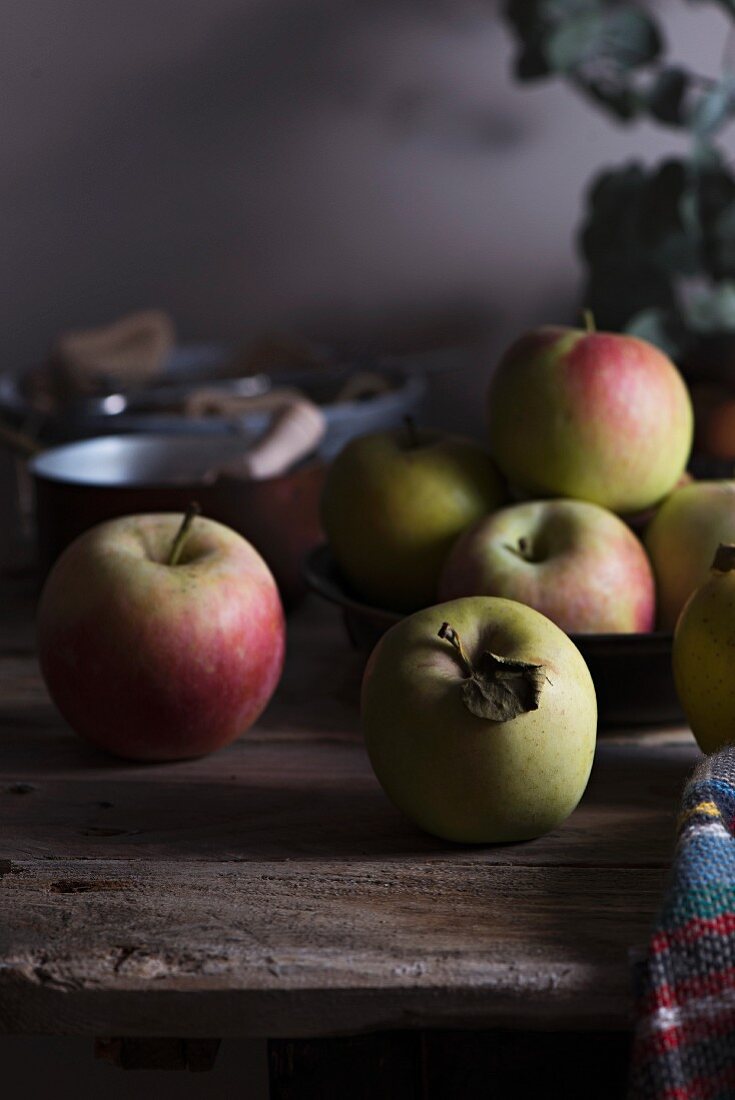 Äpfel auf rustikalem Holztisch in Küche