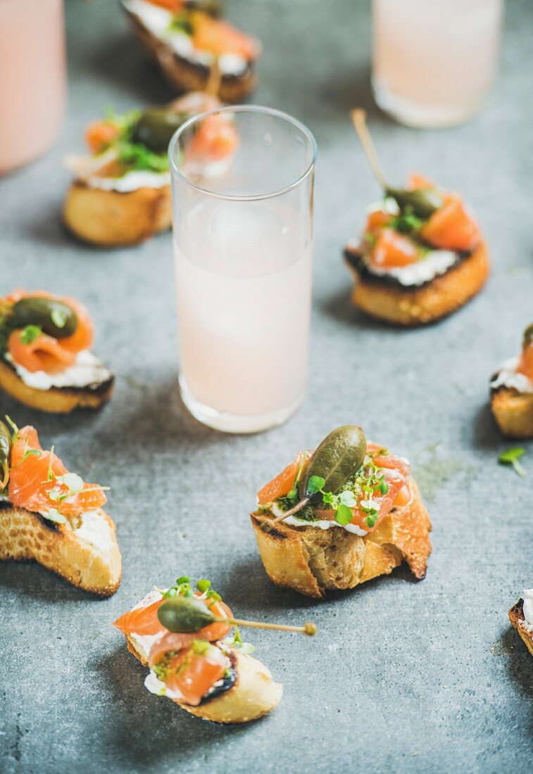 Crostini with smoked salmon, pesto sauce, watercress and capers and pink grapefruit cocktails