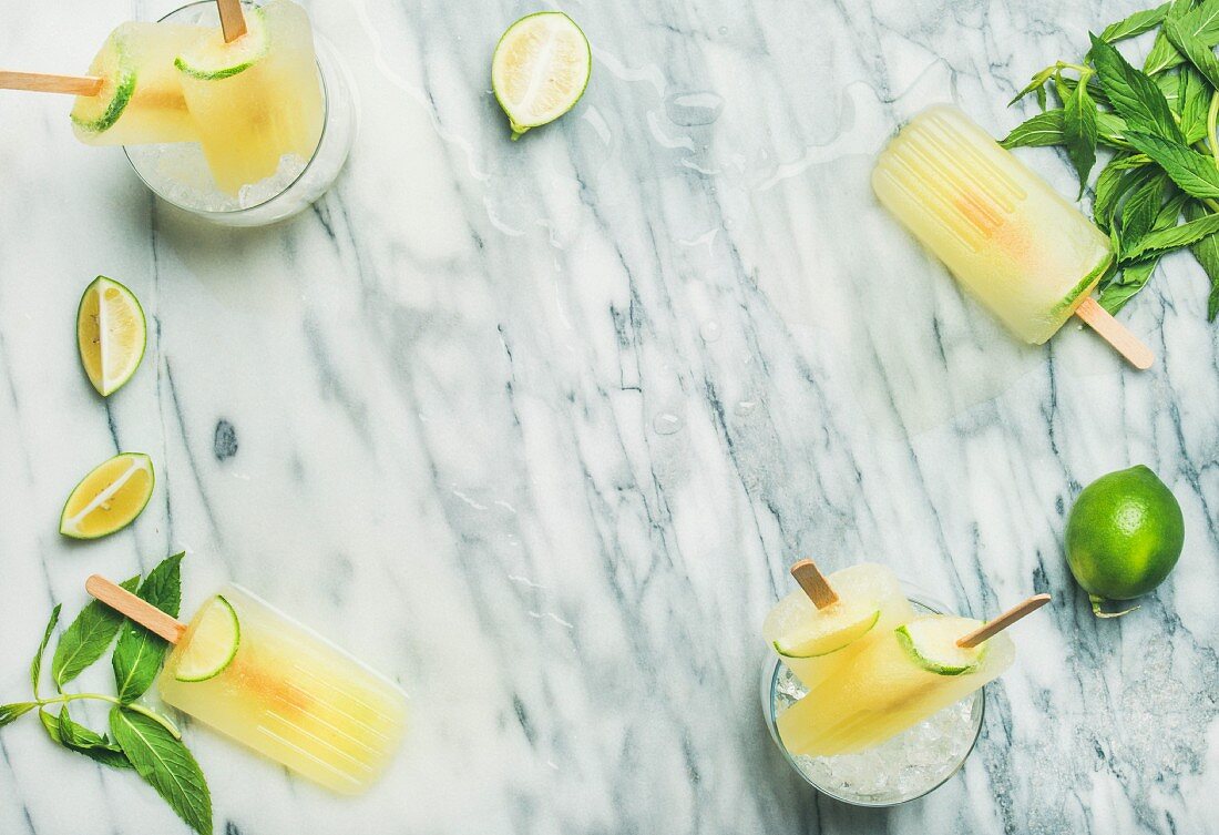 Summer refreshing lemonade popsicles with lime and mint in glasses with chipped ice