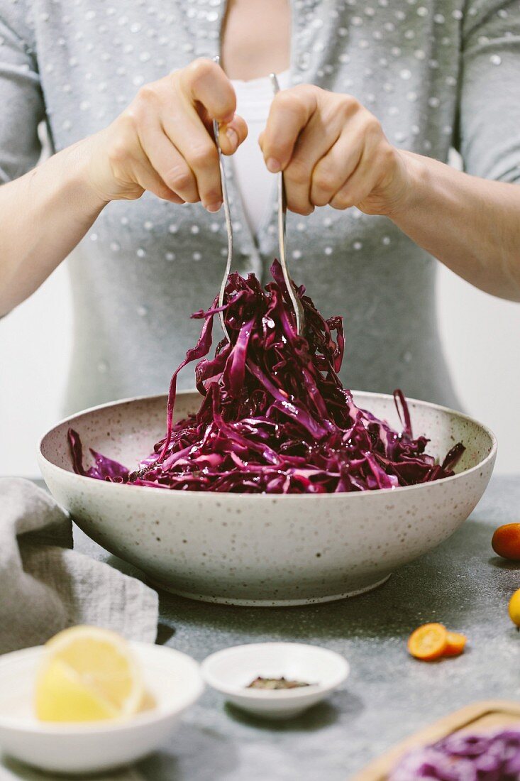 Frau beim Anrichten von Rotkohlsalat