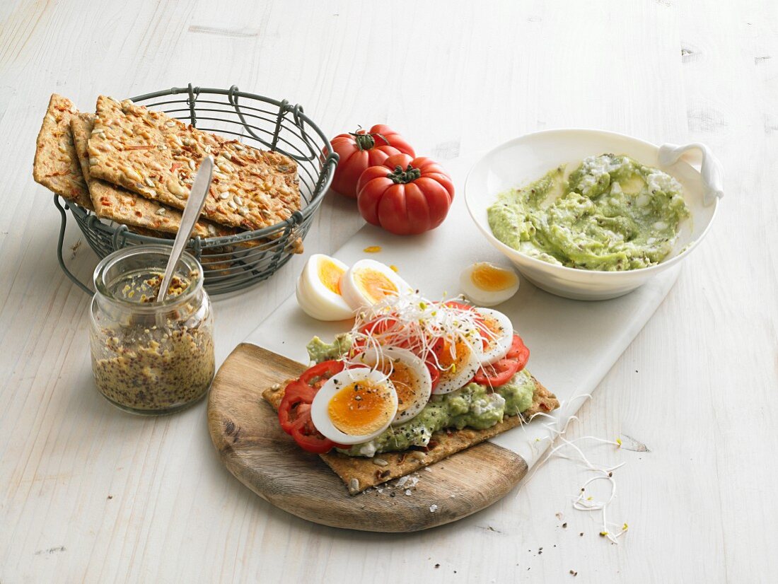 Crispbreads with avocado and cottage cheese, boiled eggs, tomatoes and sprouts