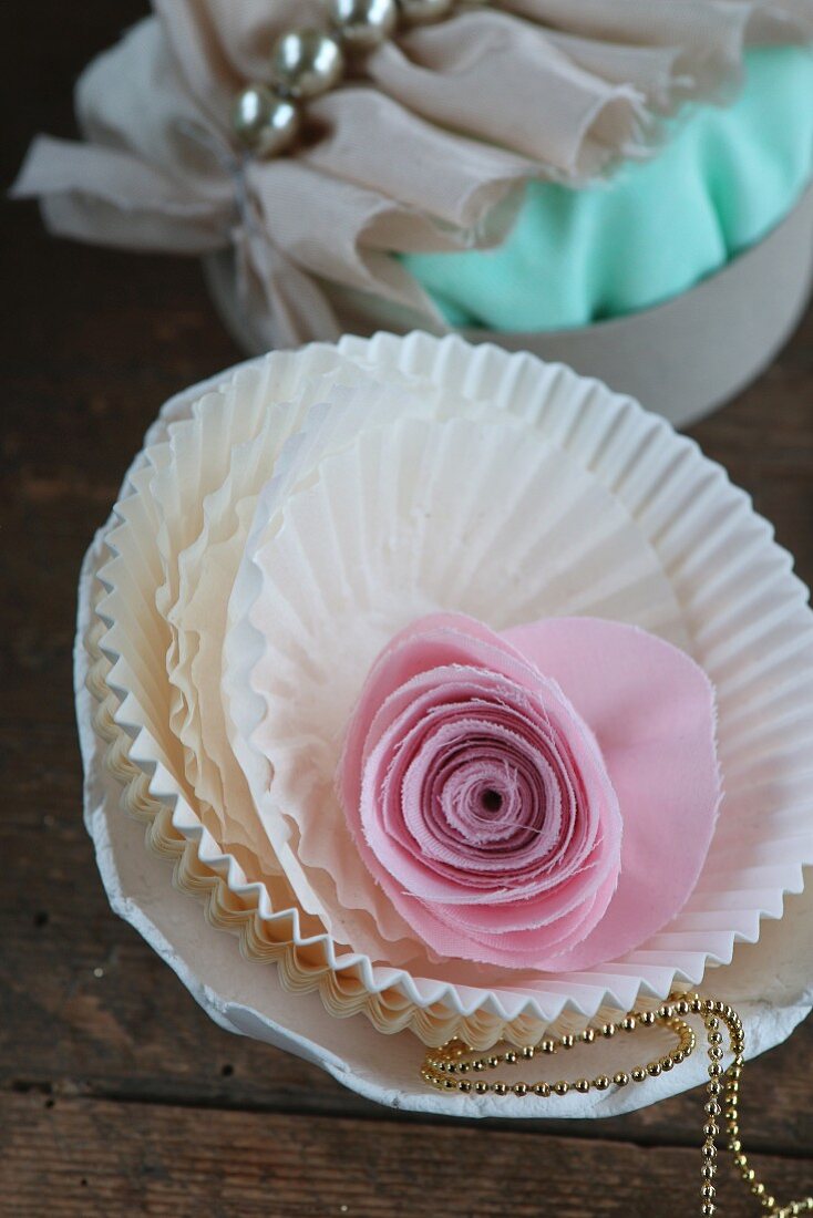 Pink fabric rose in stacked white paper cake cases