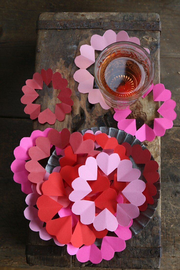 Paper coasters and collars for drinking glasses in shades of red and pink