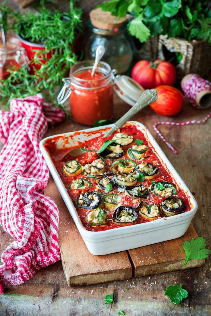 Zucchini and eggplant rolls stuffed with feta and baked in tomato sauce