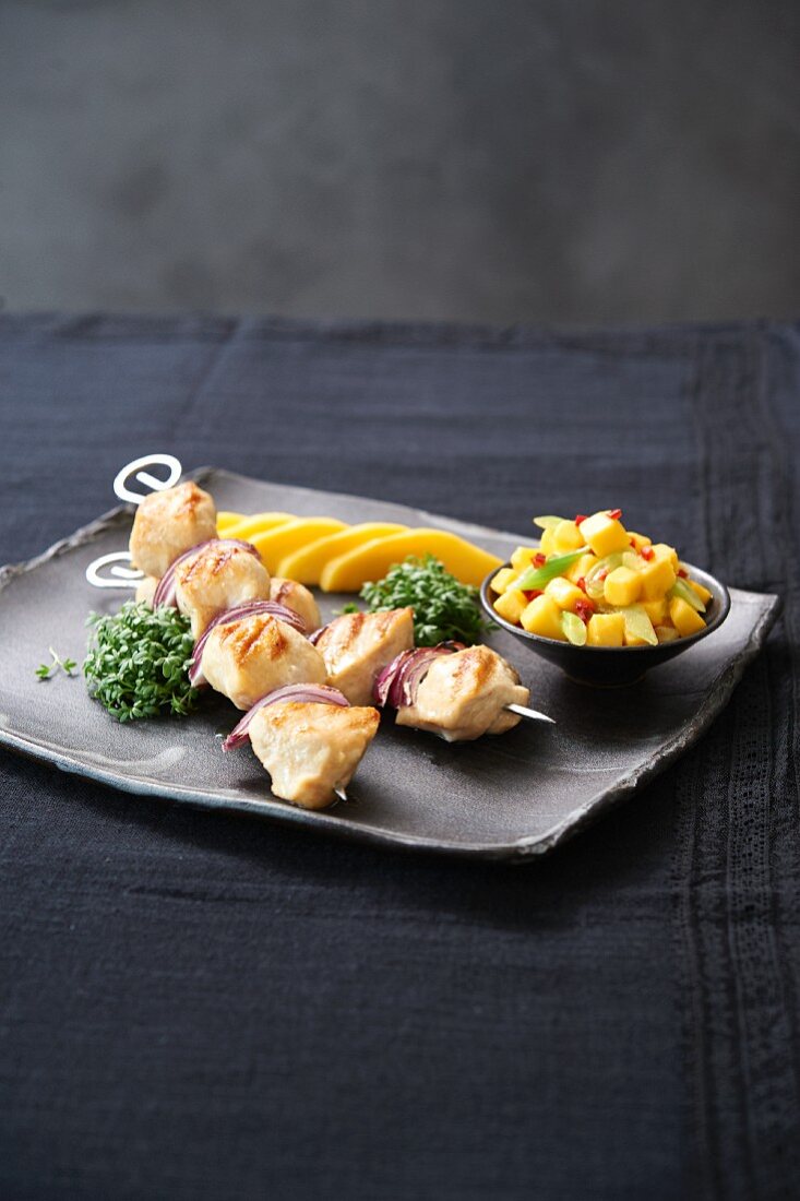 Chicken skewers with mango salsa and mango slices
