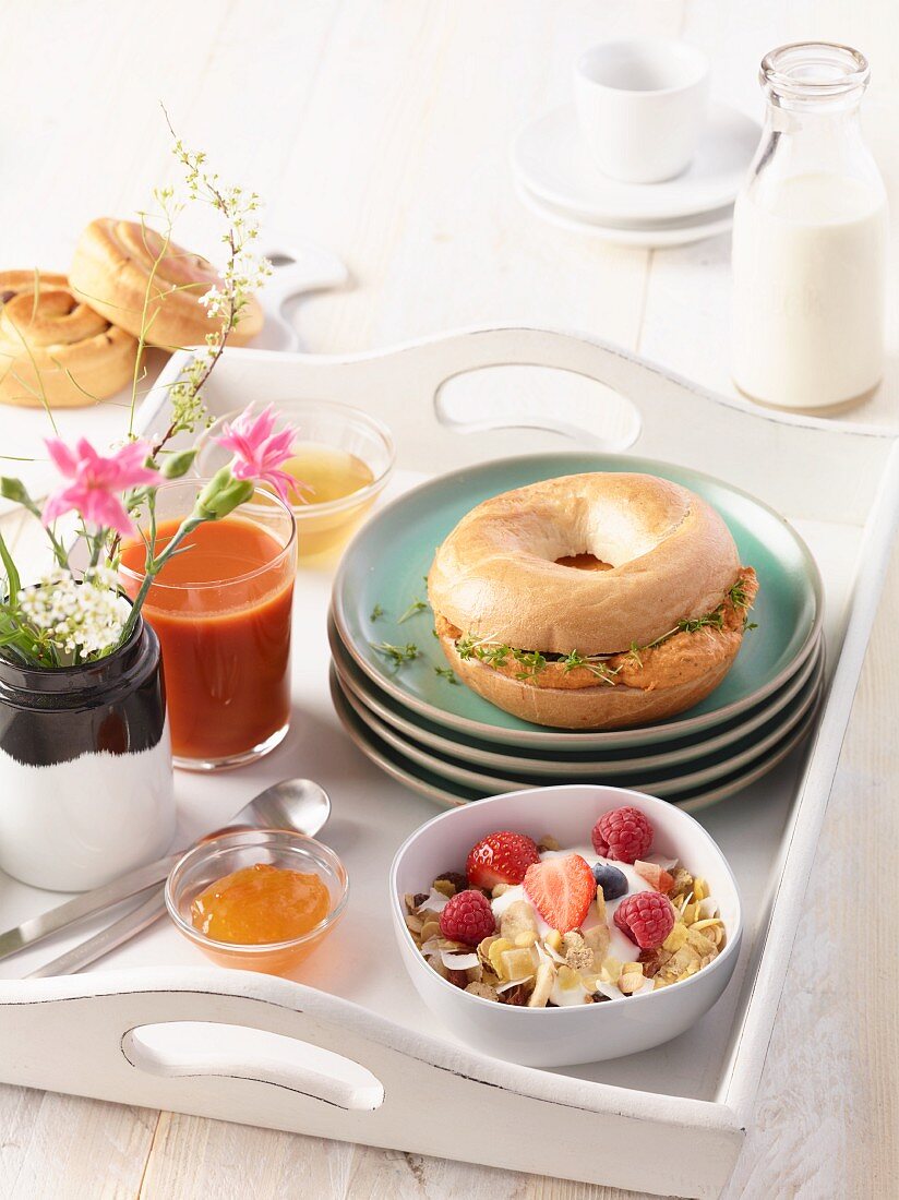 A breakfast tray with a bagel, a smoothie and some berries