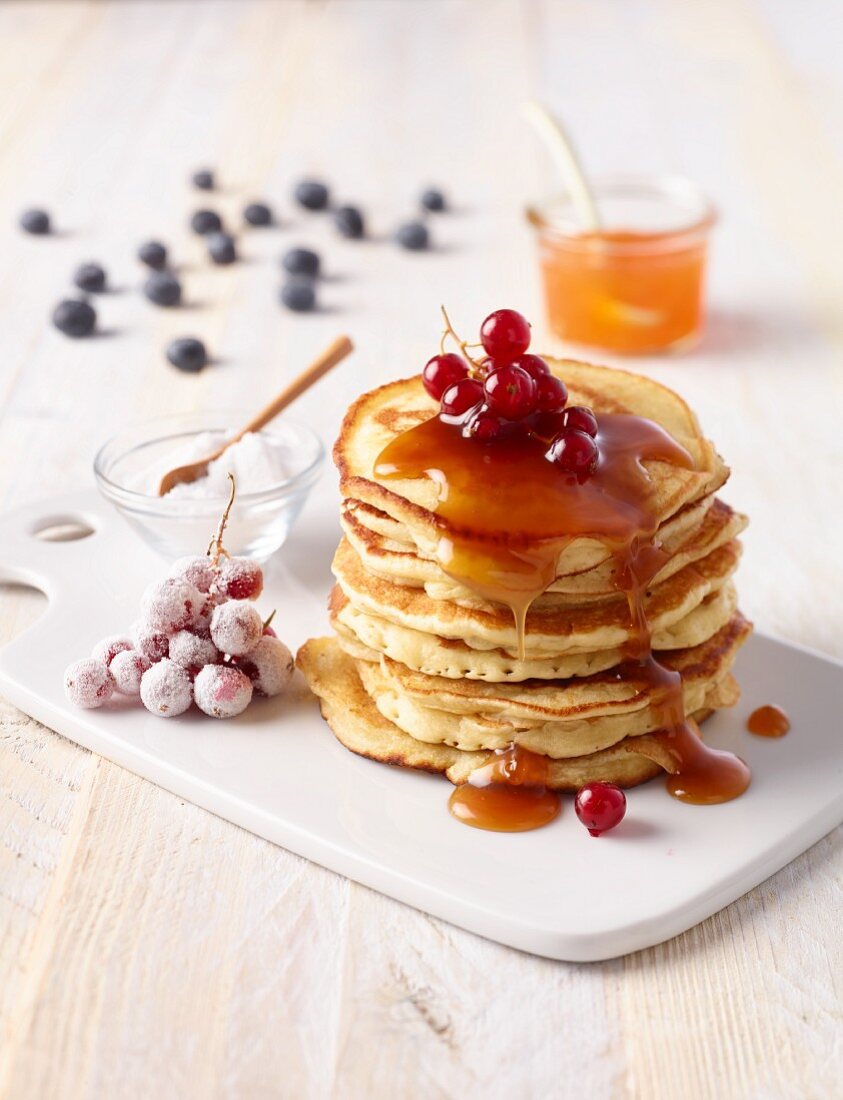 Stacked pancakes with syrup and berries