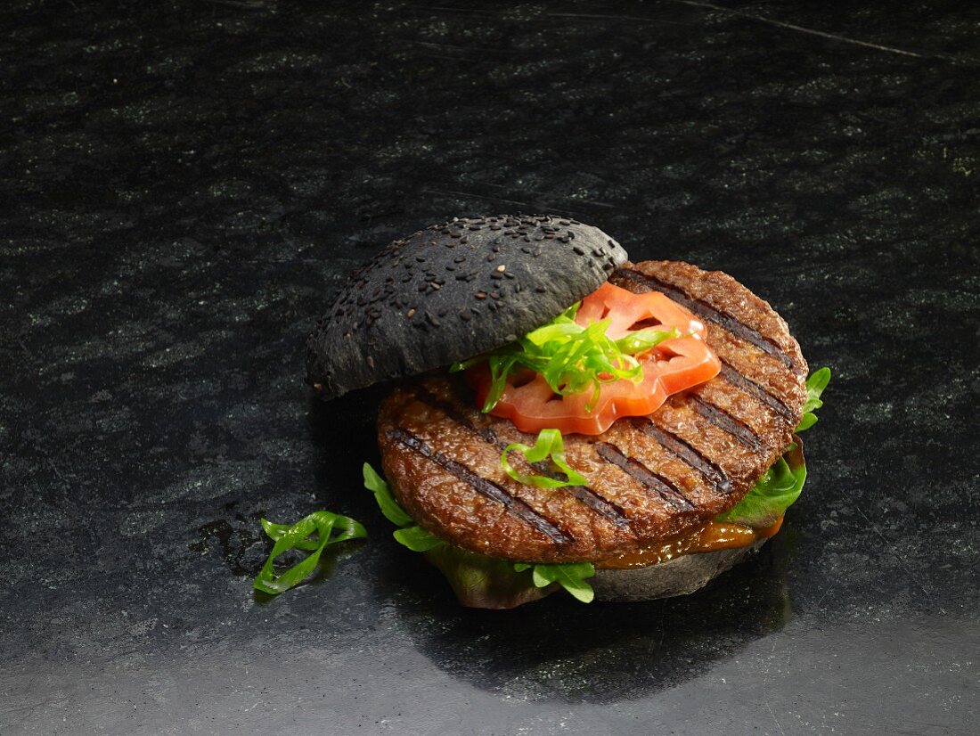 Hamburger auf schwarzem Brötchen mit Grillstreifen