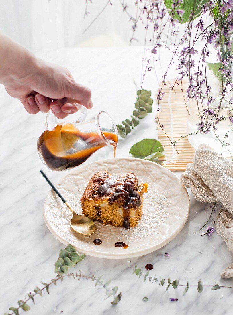 Stück Joghurtkuchen mit Bananen, Kokos und Karamellsauce