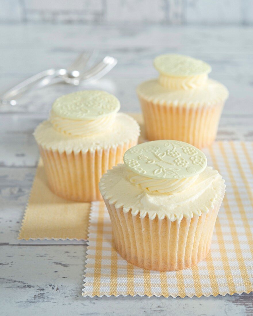 Cupcakes with cream and white chocolate disks