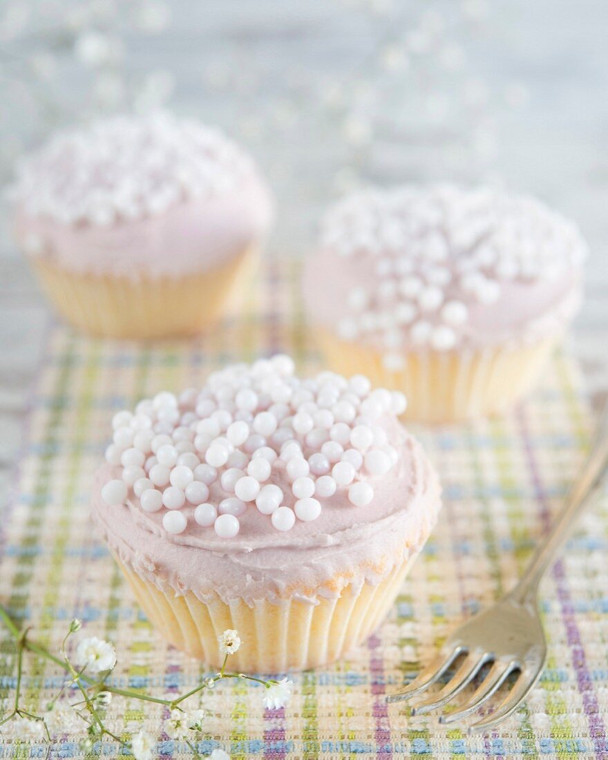 Cupcakes with buttercream and white sugar beads
