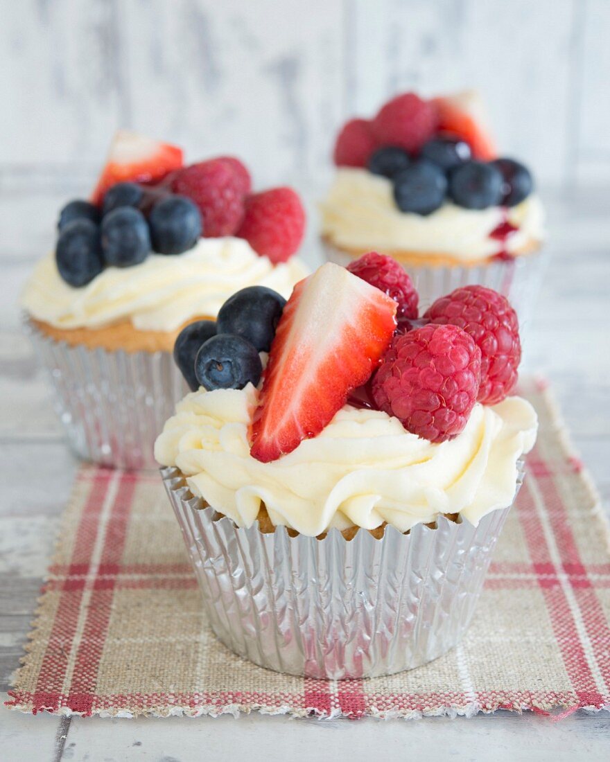 Cupcakes mit Buttercreme und frischen Beeren